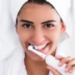 close-beautiful-woman-bathrobe-brushing-teeth