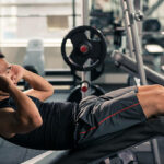 Sportsman doing crunches in the gym, side view